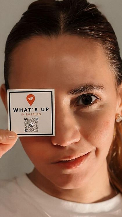 Larissa holding a What's Up sticker